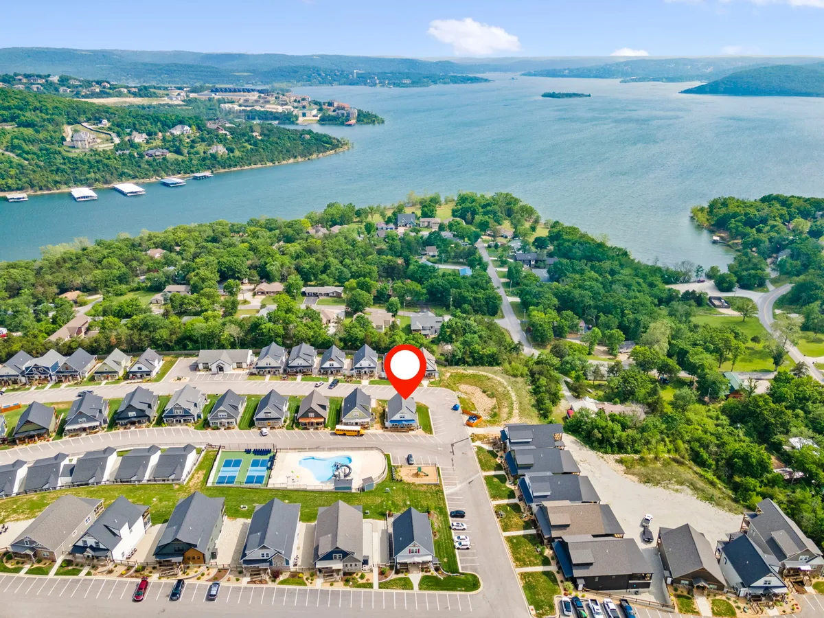 A wide view of the neighborhood showcases beautiful lake views, community homes, and the community pool. The peaceful setting hints at both the excitement of Branson’s attractions nearby and the relaxing retreat atmosphere at home.